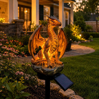 Amber Fire Dragon solar garden light glowing beside a flower bed